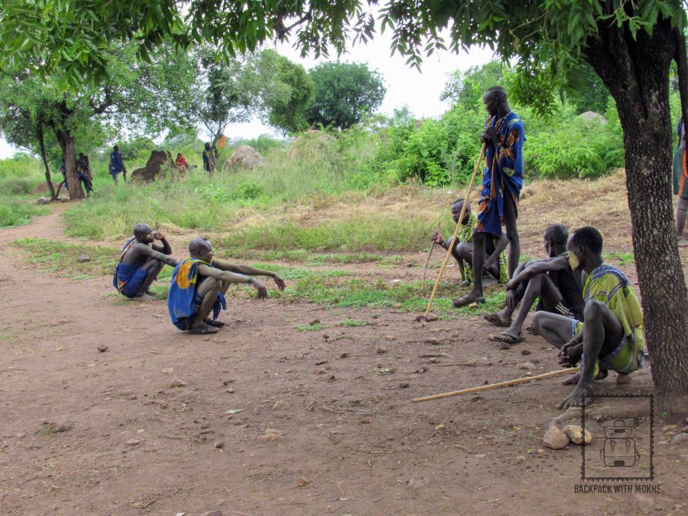 Mursi men sitting on the ground together