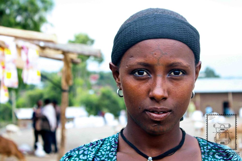 woman with cross on her forehead and designs on her jaw and neck